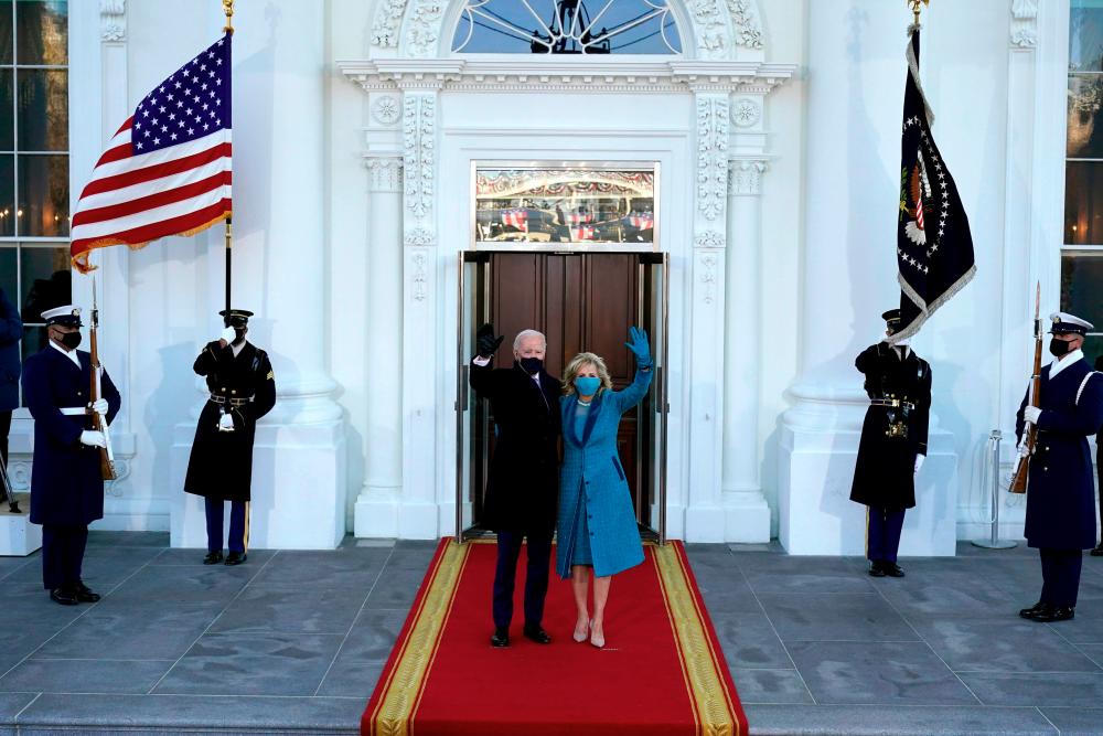 TOPSHOT - US President Joe Biden and US First Lady Jill Biden wave as they arrive at the North Portico of the White House on January 20, 2021, in Washington, DC. / AFP / POOL / Alex Brandon