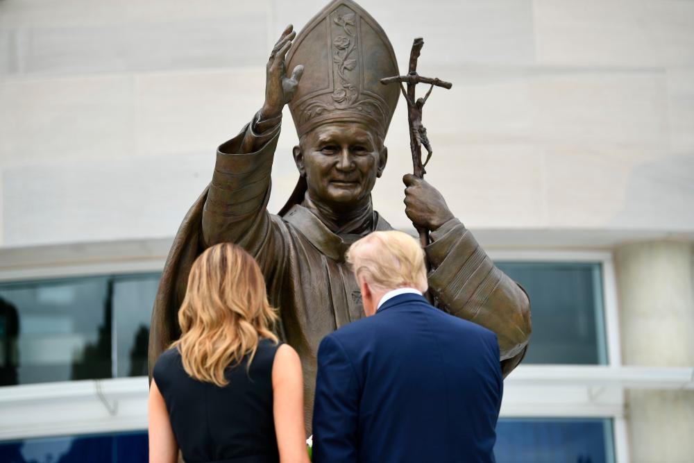 US President Donald Trump and First Lady Melania Trump visit the Saint John Paul II National Shrine, to lay a ceremonial wreath and observe a moment of remembrance under the Statue of Saint John Paul II on June 2, 2020 in Washington,DC. — AFP