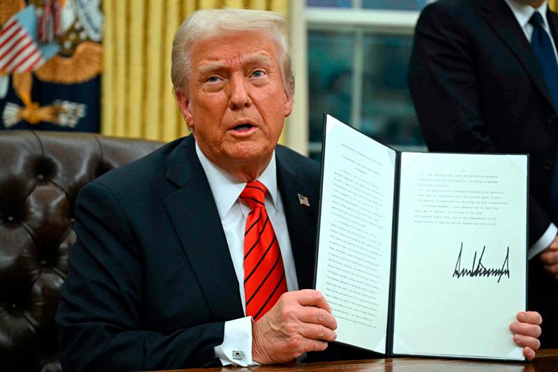 US President Donald Trump signs an executive order in the Oval Office of the White House on February 10, 2025, in Washington, DC. (Photo by ANDREW CABALLERO-REYNOLDS / AFPpix)