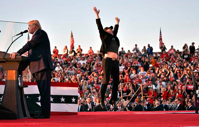 Tesla CEO Elon Musk (R) jumps on stage as he joins former US President and Republican presidential candidate Donald Trump during a campaign rally at site of his first assassination attempt in Butler, Pennsylvania on October 5