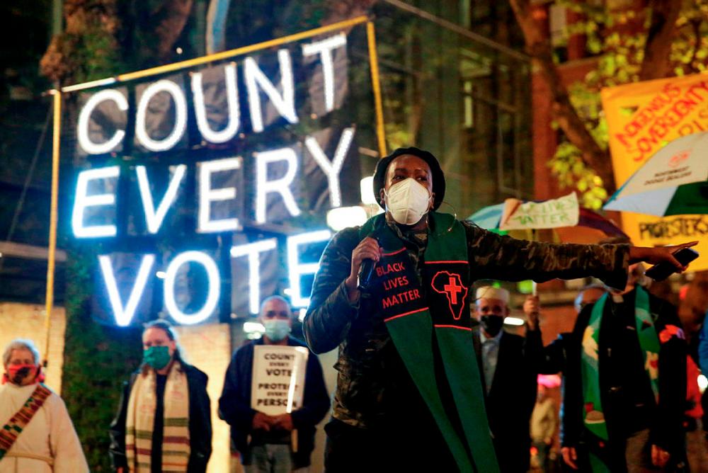 $!TOPSHOT - Reverend Bianca Davis-Lovelace of the Washington State Poor People’s Campaign speaks at a rally and march to “Count Every Vote, Protect Every Person” a day after the US Presidential Election in Seattle, Washington -AFP / JASON REDMOND