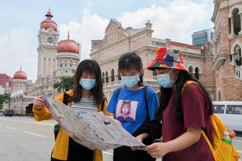 A group of Taiwanese tourists don face masks during their visit to Dataran Merdeka as a safety precaution in light of the Covid-19 outbreak. — Bernama