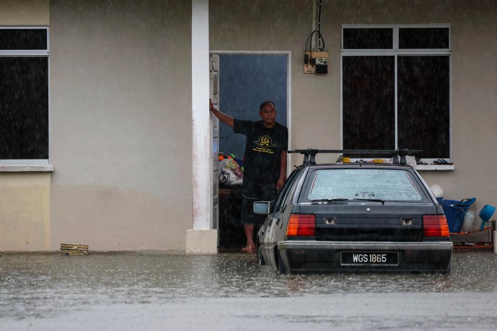 KUALA TERENGGANU, 9 Dis -- Seorang lelaki berdiri di pintu rumahnya selepas kawasan itu dilanda banjir kilat ekoran hujan lebat berterusan sejak malam tadi semasa tinjauan di Kampung Gong Tok Nasek hari ini. fotoBERNAMA