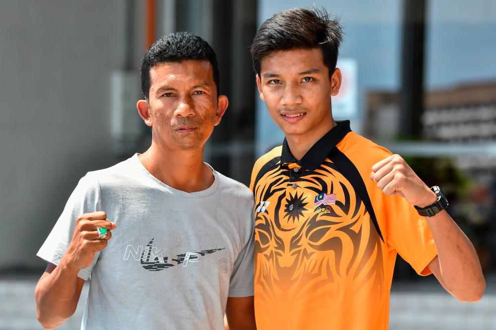 KUALA TERENGGANU, June 12-National muay Thai athlete, Ahmad Nor Iman Aliff Rakib (right) with his father Rakib Ahmad who is also the country’s legendary boxer when met here recently. BERNAMAPIX