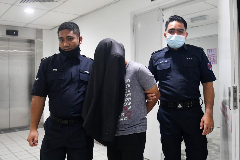 Pengawal keselamatan Muhamad Hafidz Azrul Mat Nizan, 25, (tengah) dihadapkan di Mahkamah Sesyen hari ini, atas tiga pertuduhan melakukan ugutan bunuh terhadap pegawai dan anggota polis pada November dan Disember lepas/BERNAMAPix