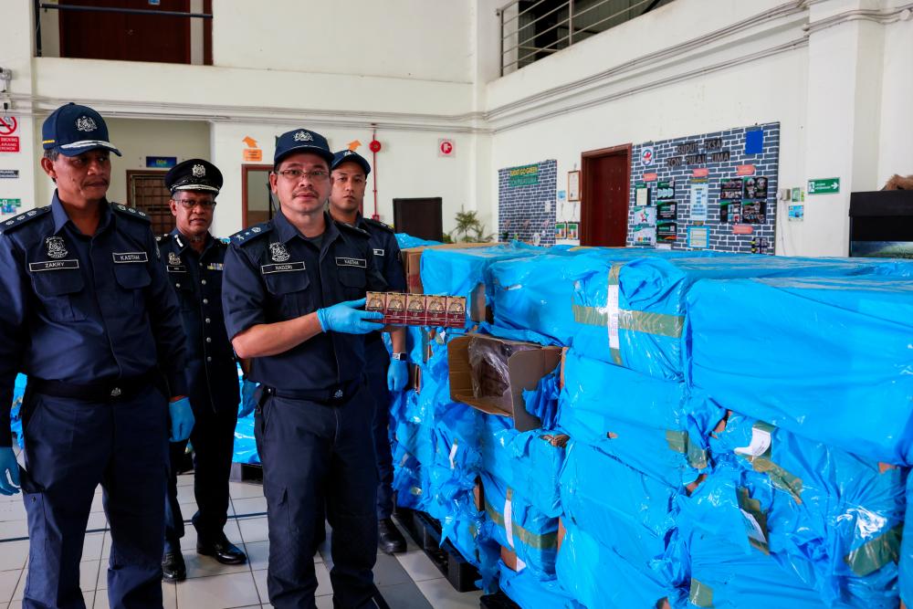 Pengarah Jabatan Kastam Diraja Malaysia (JKDM) Terengganu, Mohd Nadzri Ariffin (kanan) menunjukkan sebahagian rokok yang dirampas pada sidang media mengenai rampasan rokok di Pejabat Kastam Kemaman pada Okt 18 2023. - fotoBERNAMA