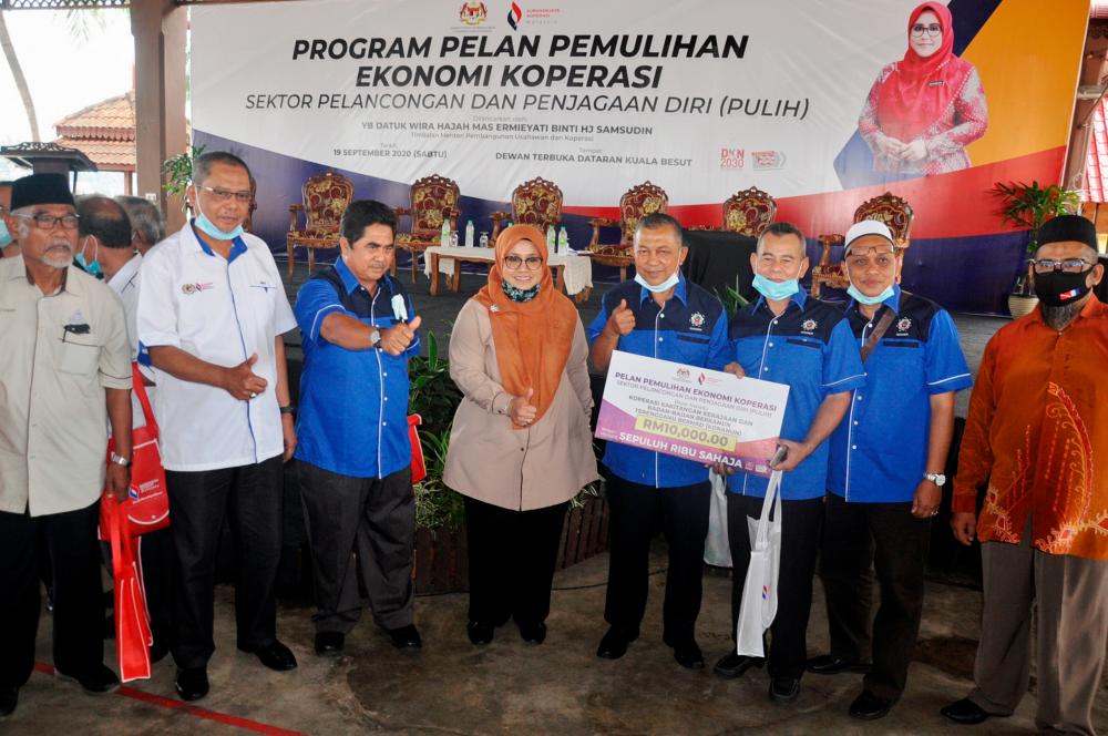 Deputy Entrepreneur Development and Cooperatives Minister Datuk Mas Ermieyati Samsudin (C) delivers aid to nine cooperatives in Terengganu after officiating the Terengganu Cooperatives Exploration programme and Launch of the Rehabilitation Programme in Kuala Besut today. — Bernama