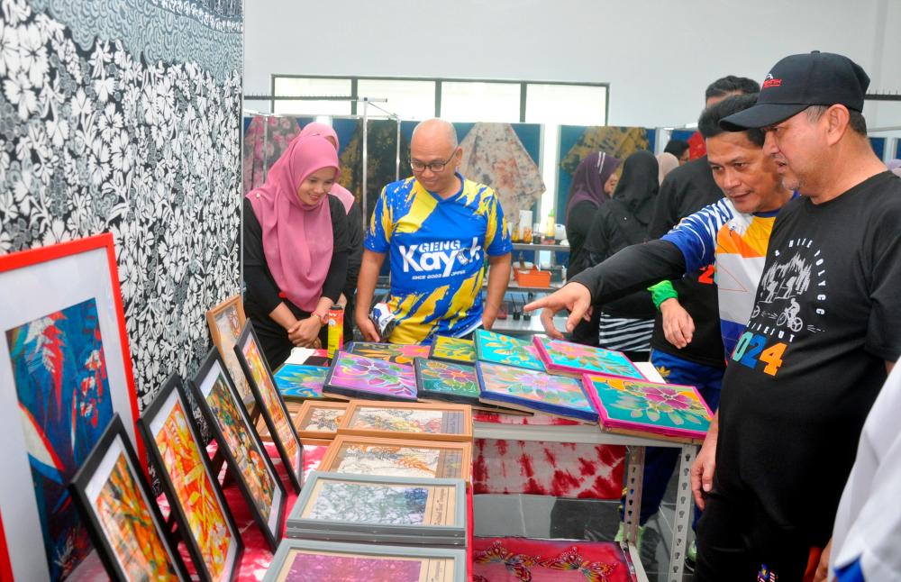 Ketua Pengarah Pendidikan Politeknik dan Kolej Komuniti, Kementerian Pendidikan Tinggi, Dr Mohd Zahari Ismail (kanan) melihat lukisan batik hasil kerja tangan pelajar semester dua Politeknik Besut sempena lawatannya ke politeknik berkenaan hari ini. - fotoBERNAMA