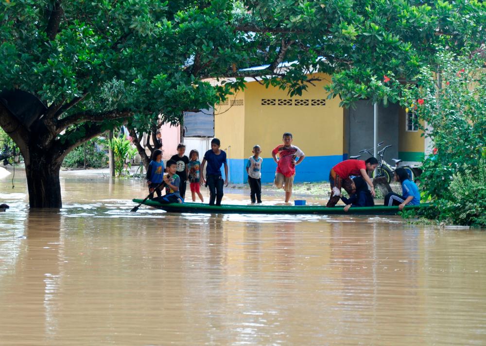 A group of children in Kampung Darau, Jertih play in the water yesterday. - Bernama