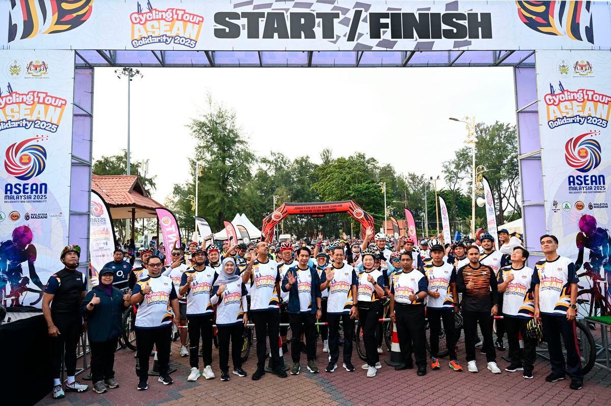 Timbalan Menteri Belia dan Sukan Adam Adli Abdul Halim (tengah) bergambar bersama peserta-peserta pada Majlis Pelepasan Cycling Tour ASEAN Solidarity di Dataran Pantai Batu Buruk hari ini. FotoBernama