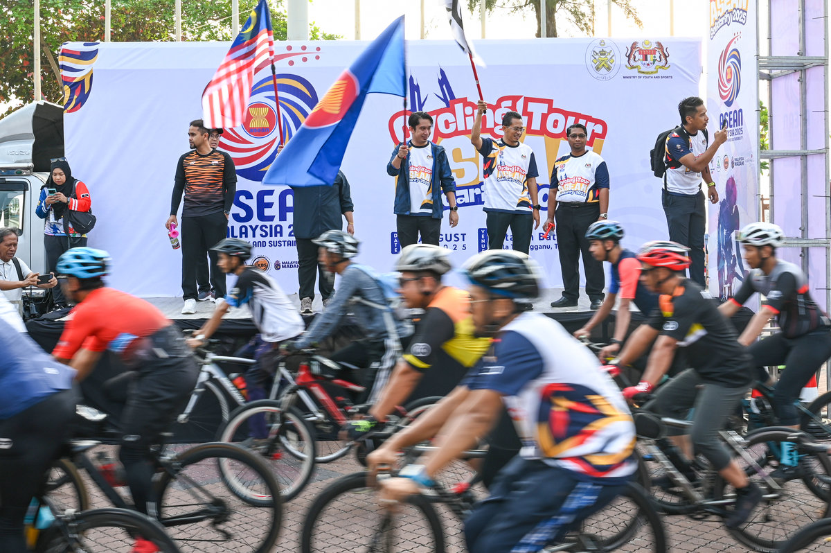 Deputy Minister of Youth and Sports, Adam Adli Abdul Halim (centre), performs the symbolic flag-off of participants of the ASEAN Solidarity Cycling Tour at Dataran Pantai Batu Buruk today. – BERNAMA