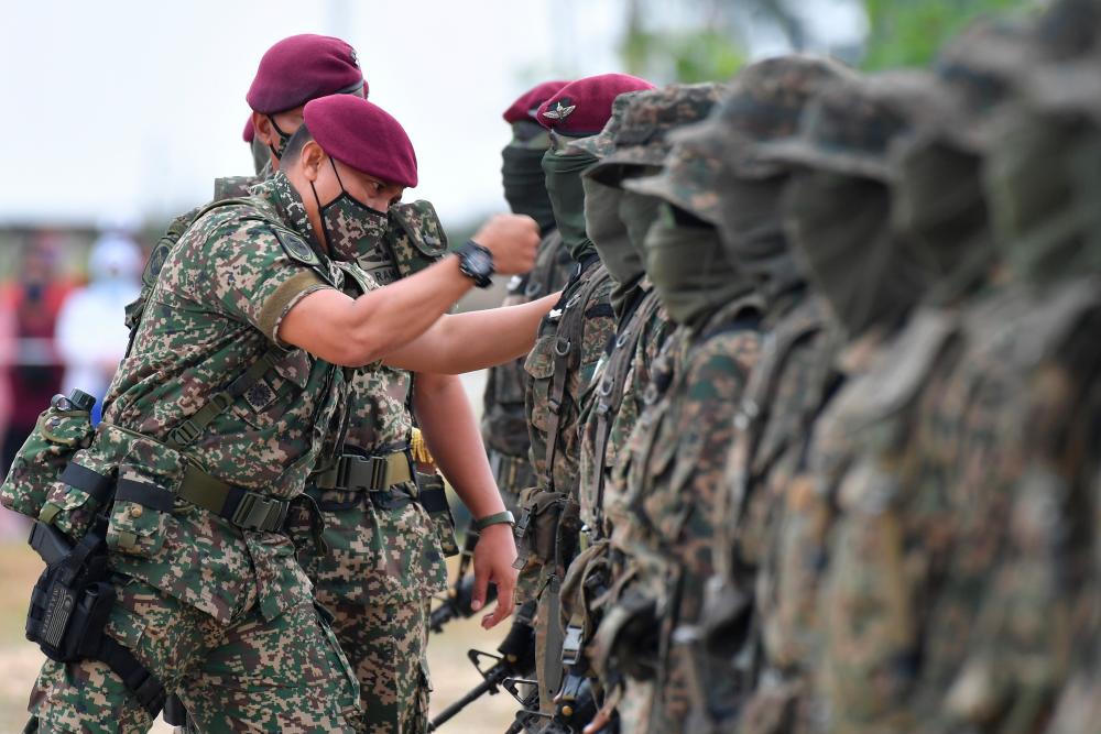 KUALA TERENGGANU, 15 Feb -- Panglima 10 Briged (Para) Brigedier Jeneral Khairul Azmizal Ahmad Natal (kiri) memakaikan beret merun dan menyemat sayap berdarah kepada anggota pada Majlis Penutup Kursus Asas Pasukan Aturgerak Cepat (APAC) Siri 2/2021 di Jambatan Angkat Kuala Terengganu hari ini. fotoBERNAMA