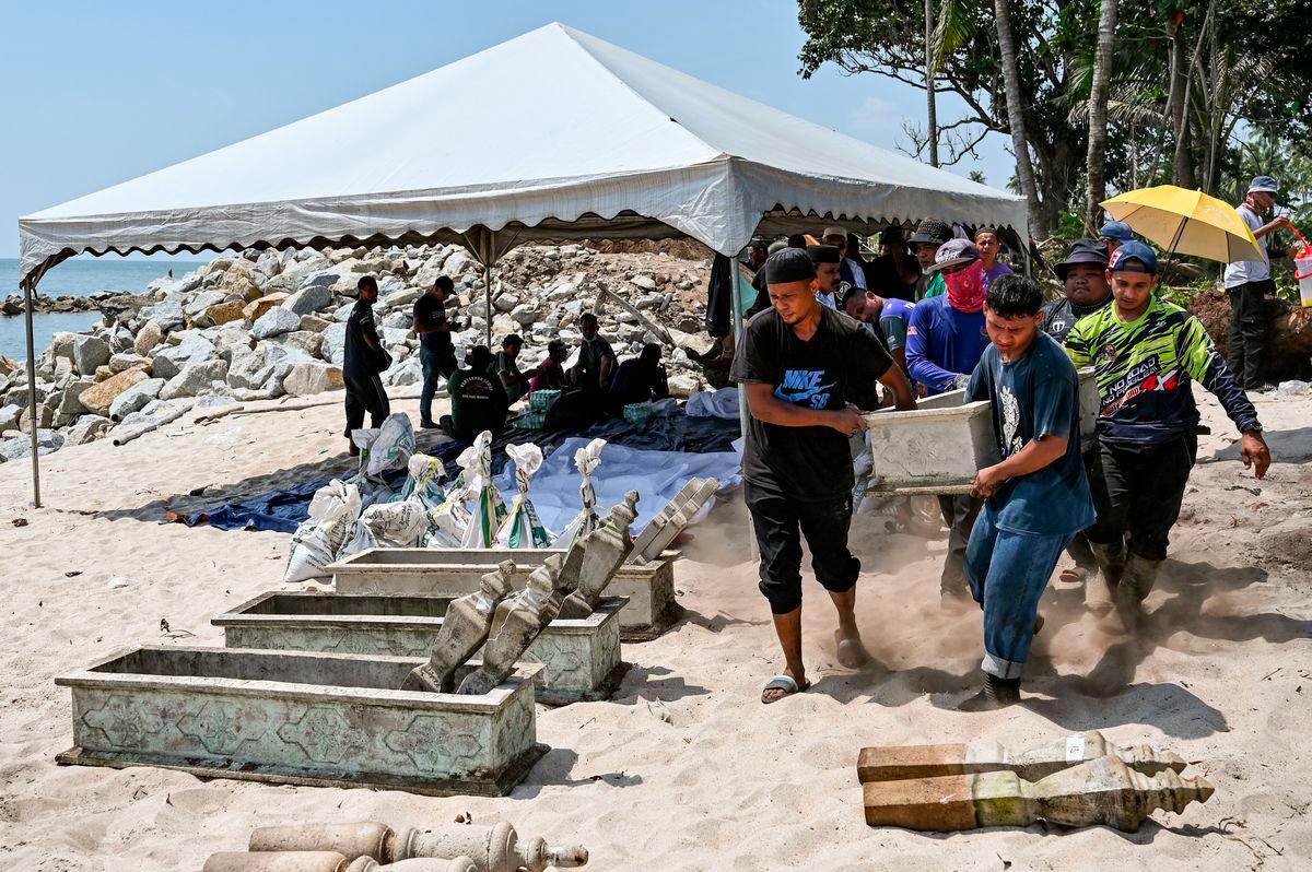 Waris dan ahli keluarga yang dipantau oleh pegawai Pejabat Agama Daerah Kuala Nerus mengangkat kepok kubur bagi proses dokumentasi jenazah selepas kubur digali semula untuk dipindahkan ke kawasan perkuburan lain semasa tinjauan di Tanah Perkuburan Islam Kampung Pengkalan Maras, hari ini. - fotoBERNAMA