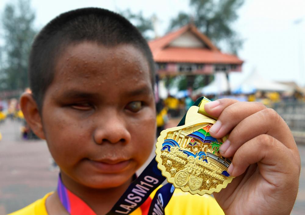 Adam Zakaria Mohd Fakhruddin poses with his medal at the Sultan Mahmud Bridge International Run 2019, on Sept 14, 2019. — Bernama