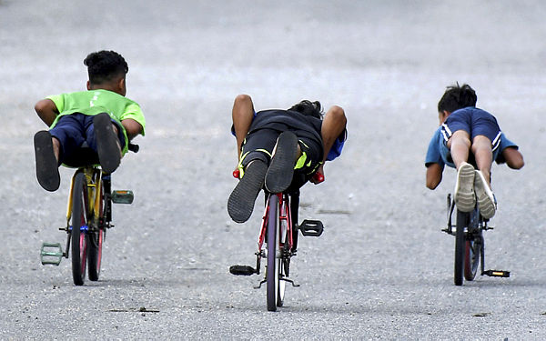 Three underage children are seen racing on ‘lajak’ bicycles at Bukit Besar, Terengganu. — Bernama