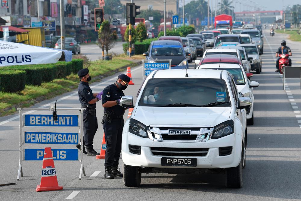 Police officers checking the letters for inter-state travel of road users when conducting a roadblocks following the implementation of the Movement Control Order (MCO) in Terengganu in Padang Midin today. Terengganu is under the implementation of MCO from today until February 4 to prevent the spread of COVID-19. -- fotoBERNAMA (2021) COPYRIGHTS RESERVED