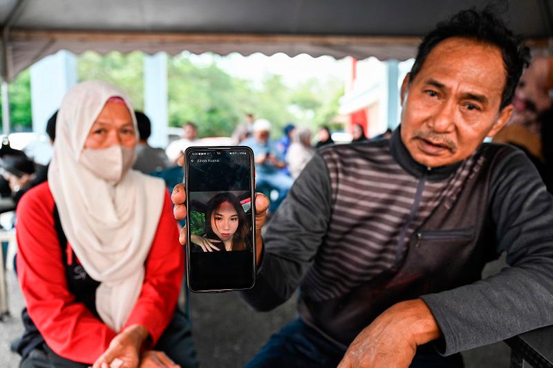 Father Mohamad Husaini Ayub, 60 (right), and wife Haziyah Harun, 63 (left), show a picture of their daughter Aina Husna Mohamad Husani, 25, who is still missing following the incident of the sinking fishing boat in Kemaman waters yesterday. - BERNAMApix