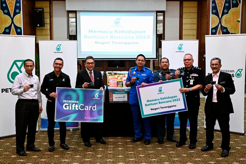 Setiausaha Kerajaan Negeri Datuk Seri Tengku Farok Hussin Tengku Abdul Jalil (tiga, kiri) bersama Pengurus Besar PETRONAS Pantai Timur Mohammad Ahmad Shazly Ramli (dua, kiri) bergambar kenangan bersama sebahagian kit bantuan banjir sempena Program Memacu Kehidupan Bantuan Bencana 2023 di sebuah hotel hari ini/BERNAMAPix