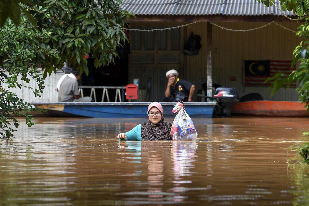 A woman moving into a temporary relief centre (PPS) near her house at Kampung Matang, on Dec 14, 2018. — Bernama
