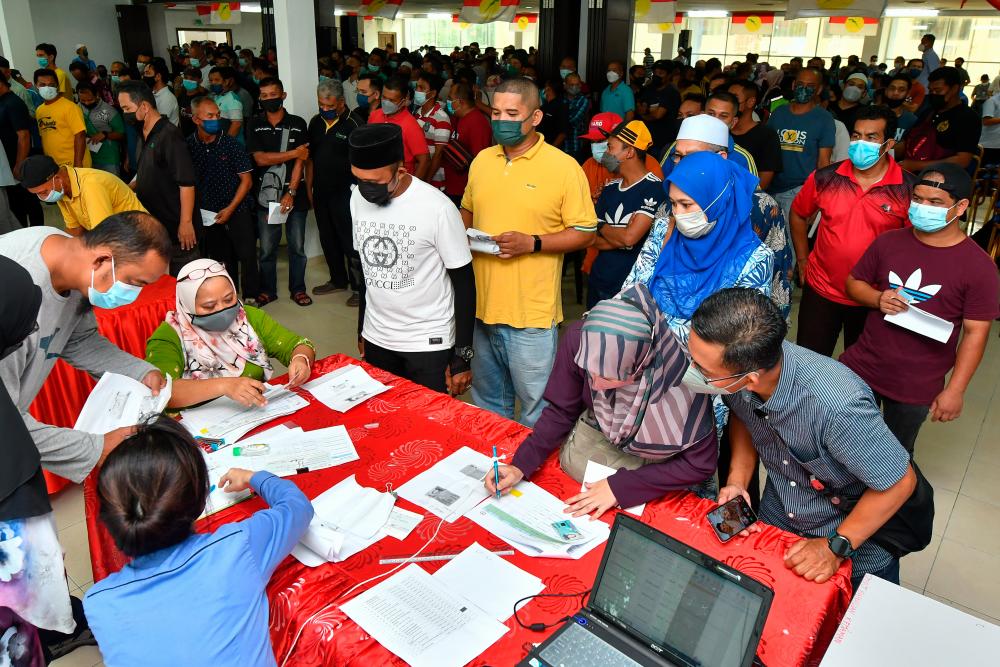 CHUKAI, 24 April -- REZEKI RAMADAN...Bekas pekerja Perwaja Steel Sdn Bhd beratur untuk menerima cek pada majlis penyampaian pampasan tunggakan gaji kepada bekas pekerja Perwaja di Pejabat UMNO Bahagian Kemaman hari ini.