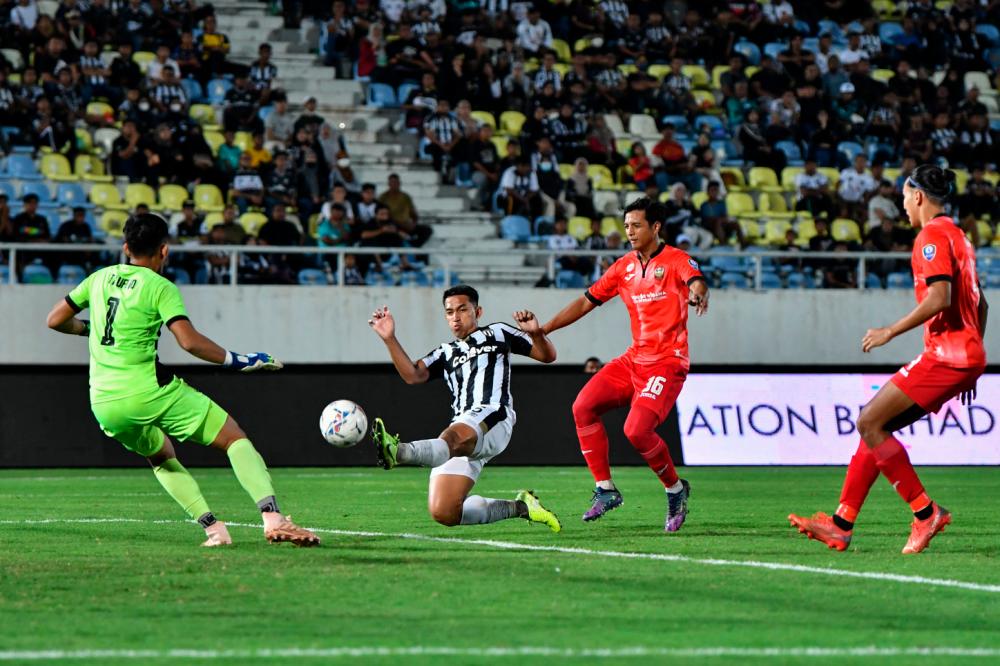 KUALA NERUS, 13 August -- Terengganu FC player Muhamad Shahrul Nizam Ros Hasni (second, left) is pushed by Sarawak United FC player Ahmad Tasnim Fitri Mohd Nasir while attempting a goal in the 2022 Super League at the Sultan Mizan Zainal Abidin Stadium in here last night BERNAMAPIX