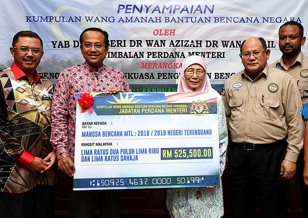 Deputy Prime Minister Datuk Seri Dr Wan Azizah Wan Ismail (C) hands over a mock cheque of KWAABN funds to Terengganu Mentri Besar Dr Ahmad Samauri Mokhtar (2nd from L) at a special media conference in Kuala Terengganu on the post-northeast monsoon 2018/2019 situation in Terengganu. — Bernama