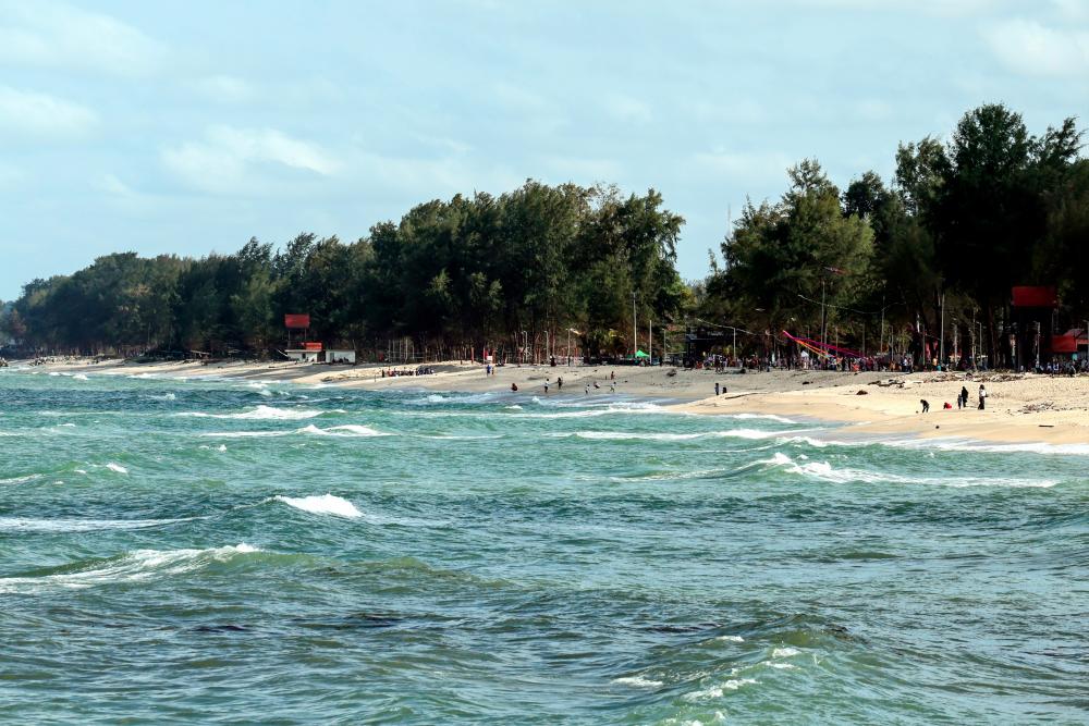 Pengunjung beriadah di persisir pantai sempena cuti persekolahan semasa tinjauan di Pantai Batu Buruk. - fotoBERNAMA