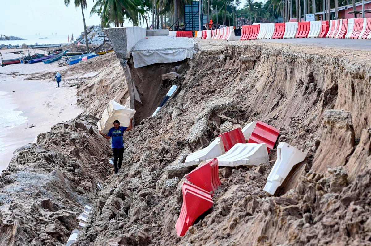 A contractor worker inspects the aftermath of a severely damaged embankment structure, believed to have collapsed due to coastal erosion last night, during a site visit at Kampung Tanjung today. - BERNAMA