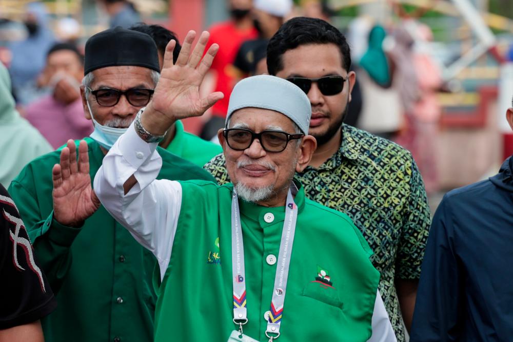 PAS President Tan Sri Abdul Hadi Awang (middle) who is also the Marang candidate is seen waving to the press while at the polling station in Sekolah Kebangsaan Rusila to cast his vote for the 15th General Election on Nov 19 2022 - BERNAMAPIX