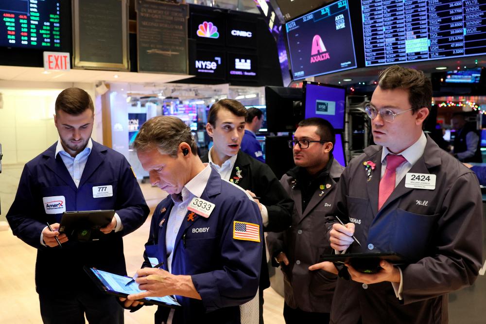 Traders gathering at the post that trades Alaska Airlines stock on the floor at the New York Stock Exchange on Monday. – Reuterspic