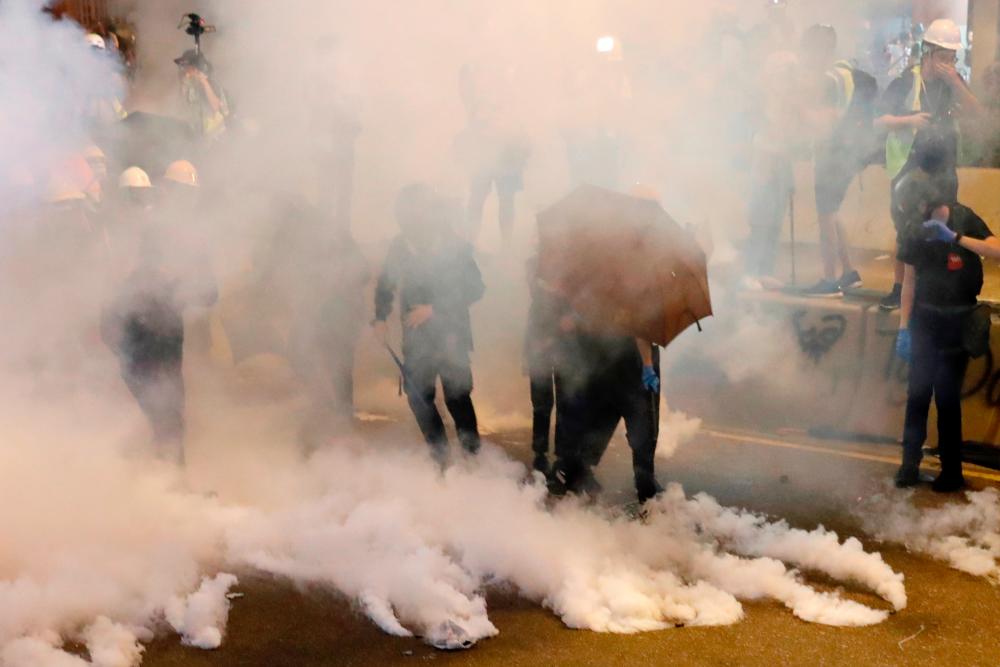 Anti-extradition bill demonstrators react as riot police fire tear gas after a march to call for democratic reforms, in Hong Kong, China July 21, 2019. — Reuters