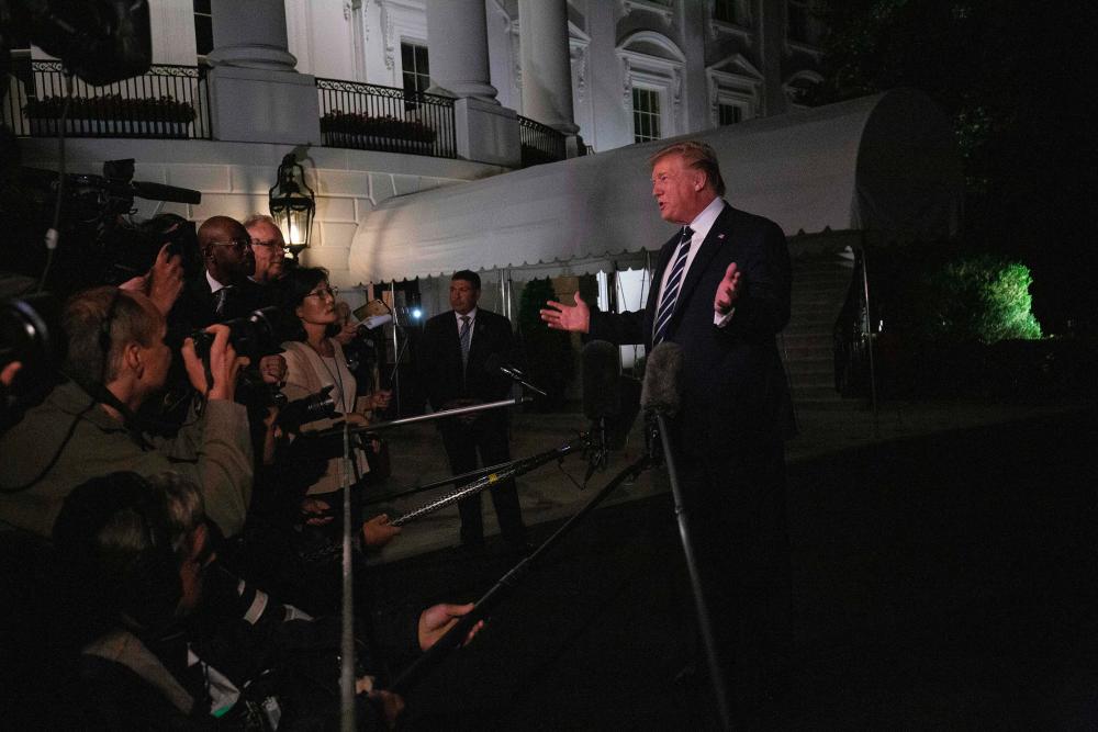 US President Donald Trump speaks to the press as he departs the White House in Washington, DC, on August 23, 2019, for the G7 Summit in France. - AFP