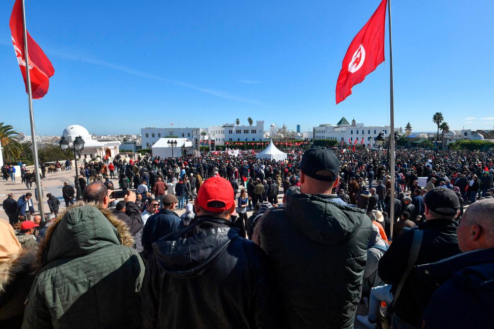 Trade unionists raise national flags and placards as they take to the streets of Tunis to protest against a proposed legislation that will grant the government sweeping powers over NGOs, on March 2, 2024/AFPPix