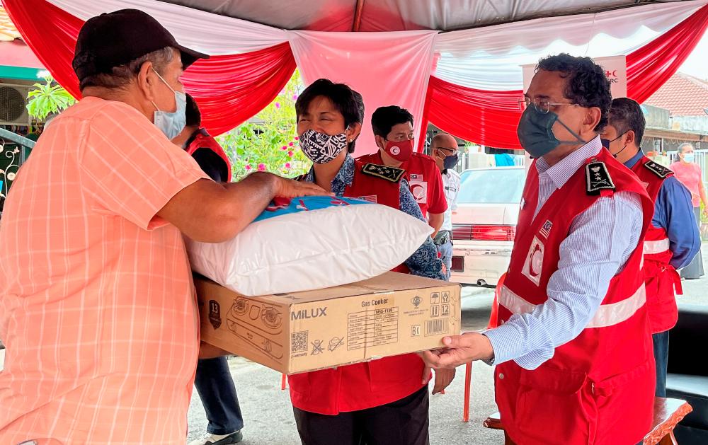 Tunku Temenggong Kedah merangkap Pengerusi Persatuan Bulan Sabit Merah Malaysia (PBSMM) Tan Sri Tunku Puteri Intan Safinaz Almarhum Sultan Abdul Halim Mua'dzam Shah (tengah) menyampaikan sumbangan kepada mangsa banjir pada Program Bantuan Pasca Banjir di Seksyen 24 Shah Alam hari ini.  BERNAMApix