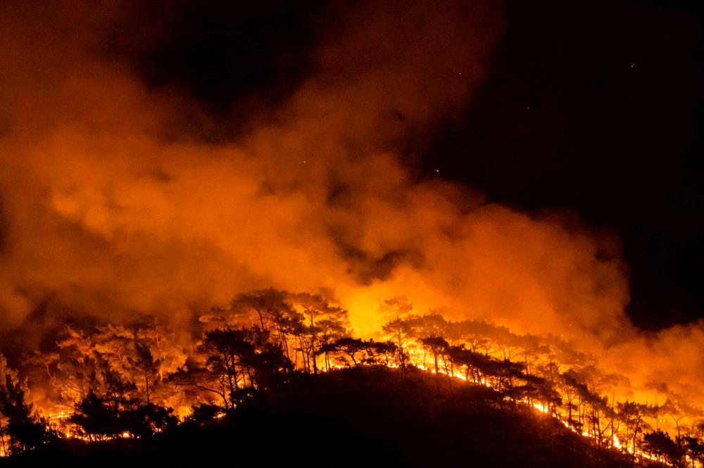 This photograph shows a forest burning as a massive wildfire engulfed a Mediterranean resort at the Marmaris district of Mugla, on August 1 2021. -AFP