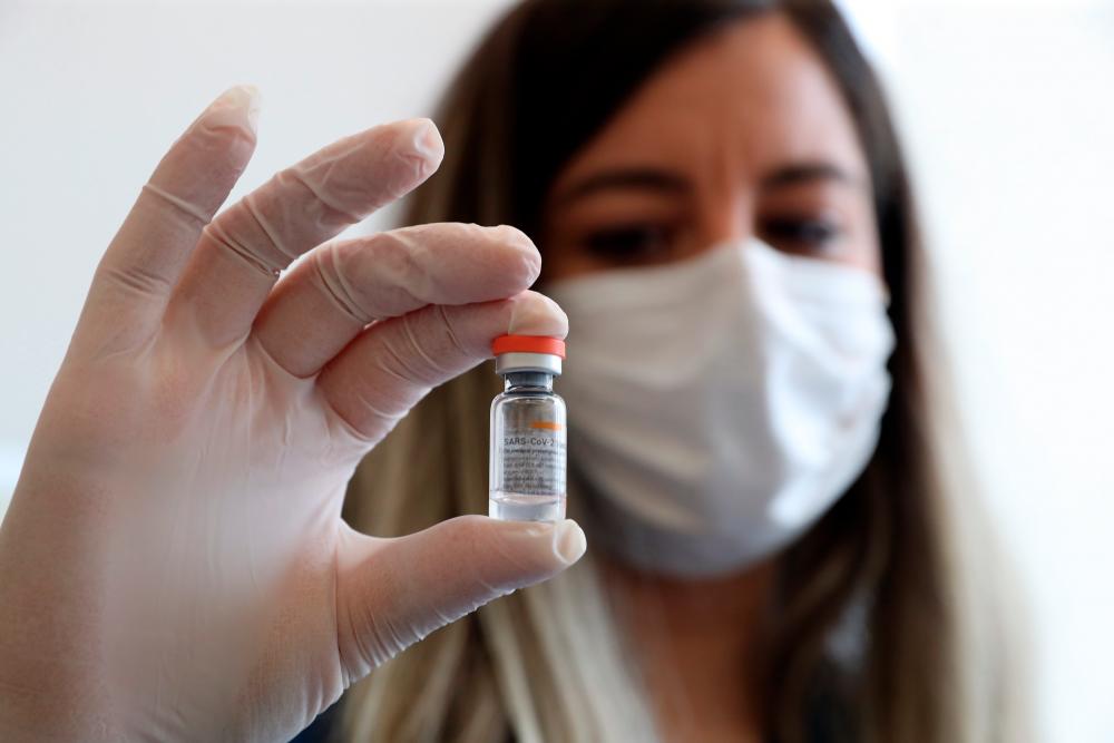 A health worker shows a dose of CoronaVac vaccine during a coronavirus (COVID-19) vaccination campaign in Ankara, Turkey on January 27, 2021. Turkey began the campaign with the CoronaVac jab produced by China’s Sinovac in mid-January. / AFP / Adem ALTAN
