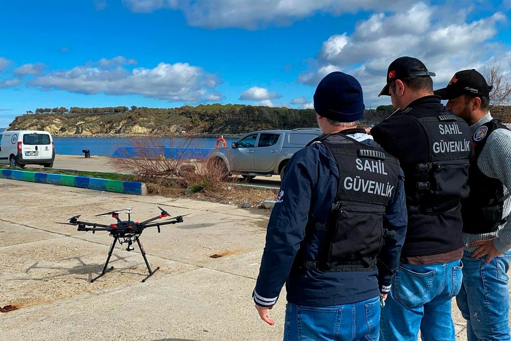 This handout photograph taken and released on March 15, 2024 in Canakkale by Turkish news agency DHA (Demiroren News Agency) shows coast guard officers operating a drone for victim search, after at least eight migrants drowned after a boat carrying them capsized off the Turkish coast in the Aegean Sea/AFPPix