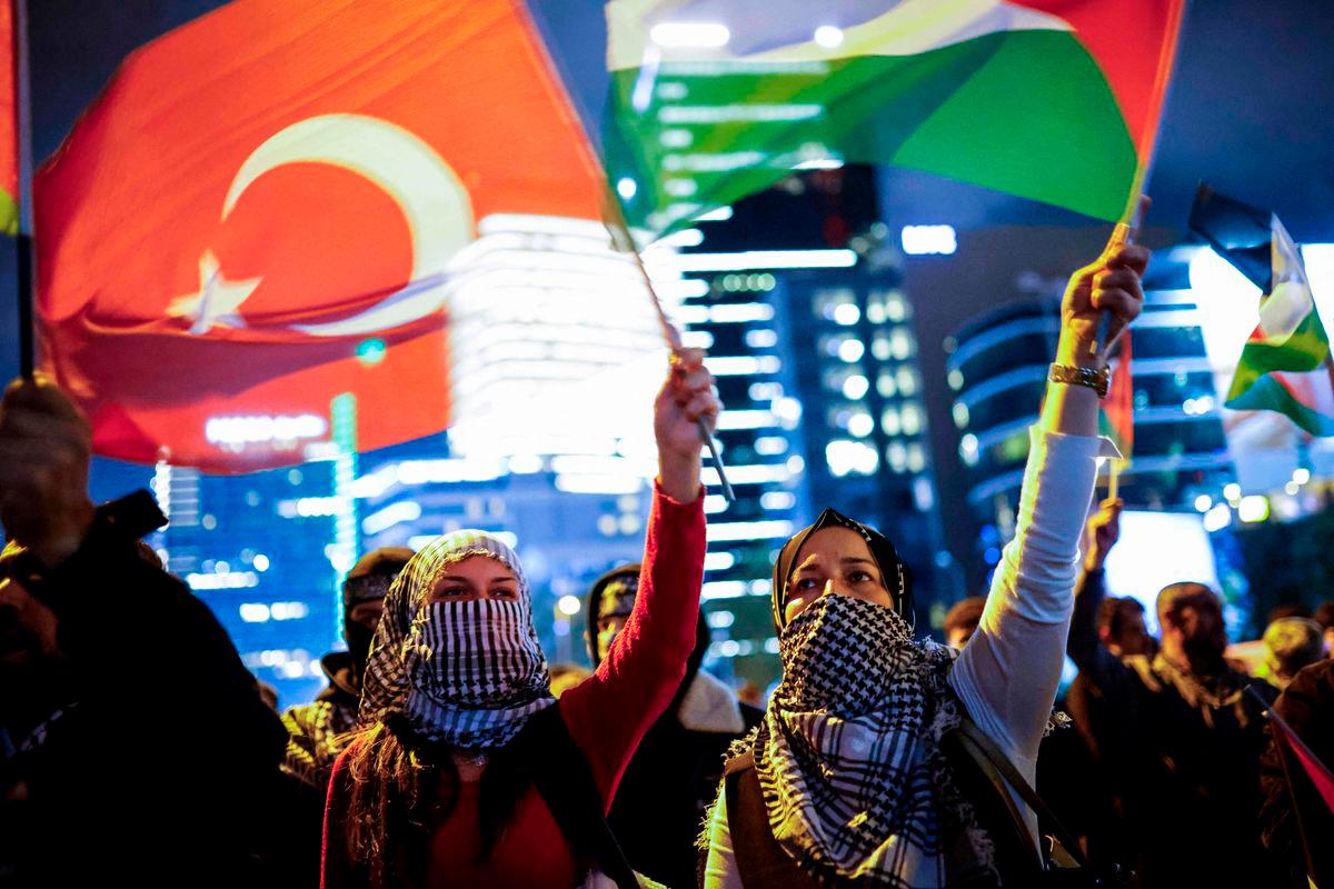 Demonstrators wave Palestinian and Turkish flags during a rally in solidarity with Palestinians and to condemn the interception of the Global Sumud Flotilla by Israeli army, in Istanbul on October 2, 2025. (Photo by KEMAL ASLAN / AFP)