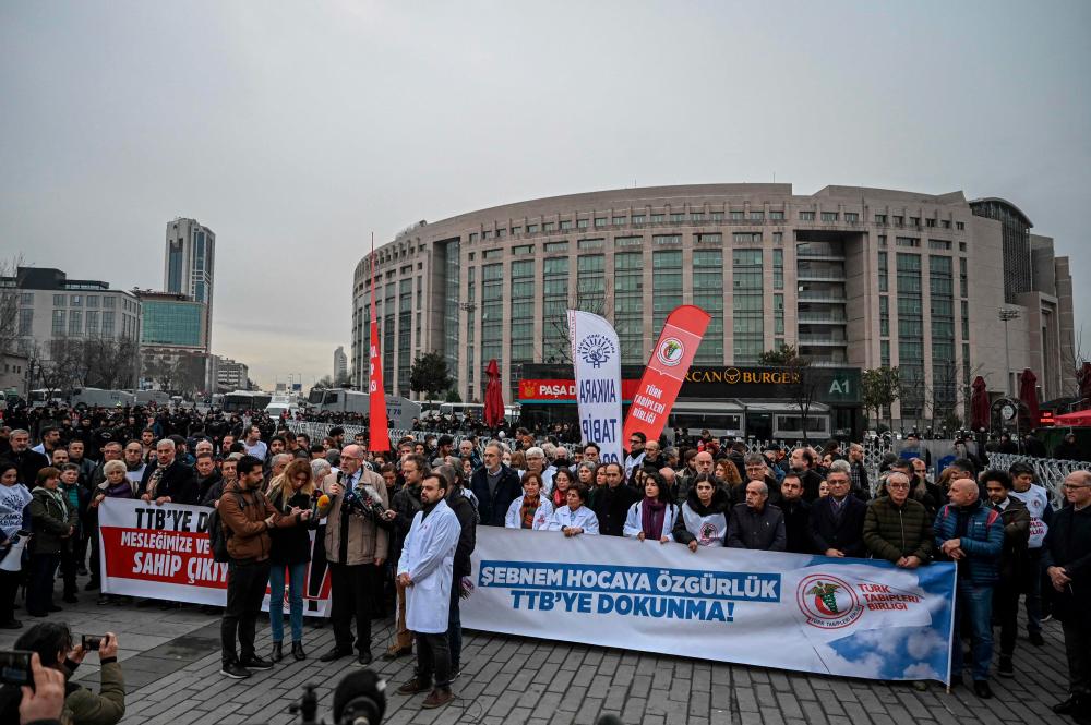 Doctors speak in front of protesters holding a banner reading “Do not touch my union- Freedom for Sebnem” outside Istanbul’s courthouse, where the trial of the head of Turkey’s main medical union, Sebnem Korur Fincanci, on “terror” charges takes place on January 11, 2023. AFPPIX