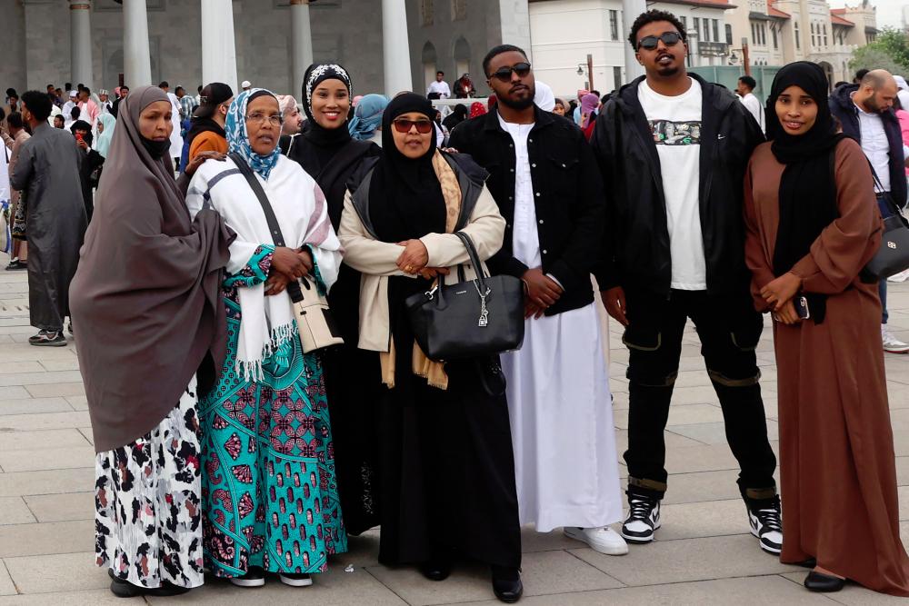 Foreign Muslims living in Turkey pose for pictures after the prayers at the Melike Hatun Mosque during the Eid al-Fitr celebrations marking the end of the Muslim holy month of Ramadam, in Ankara. - AFPpix