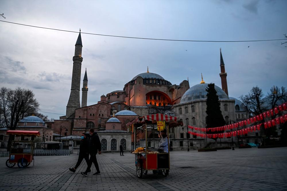 A street vendor sells rice at the Sultanahmet Square, with the Hagia Sophia Holy Grand Mosque in background, on the first day of the Muslim fasting month of Ramadan in Istanbul on April 13, 2021. –AFP