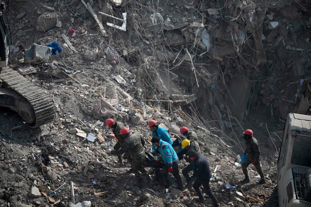 Search and rescue team evacuate a body from the rubble of collapsed buildings in Kahramanmaras on February 14, 2023, a week after an earthquake devastated parts of Turkey and Syria leaving more than 35,000 dead and millions in dire need of aid/AFPPix