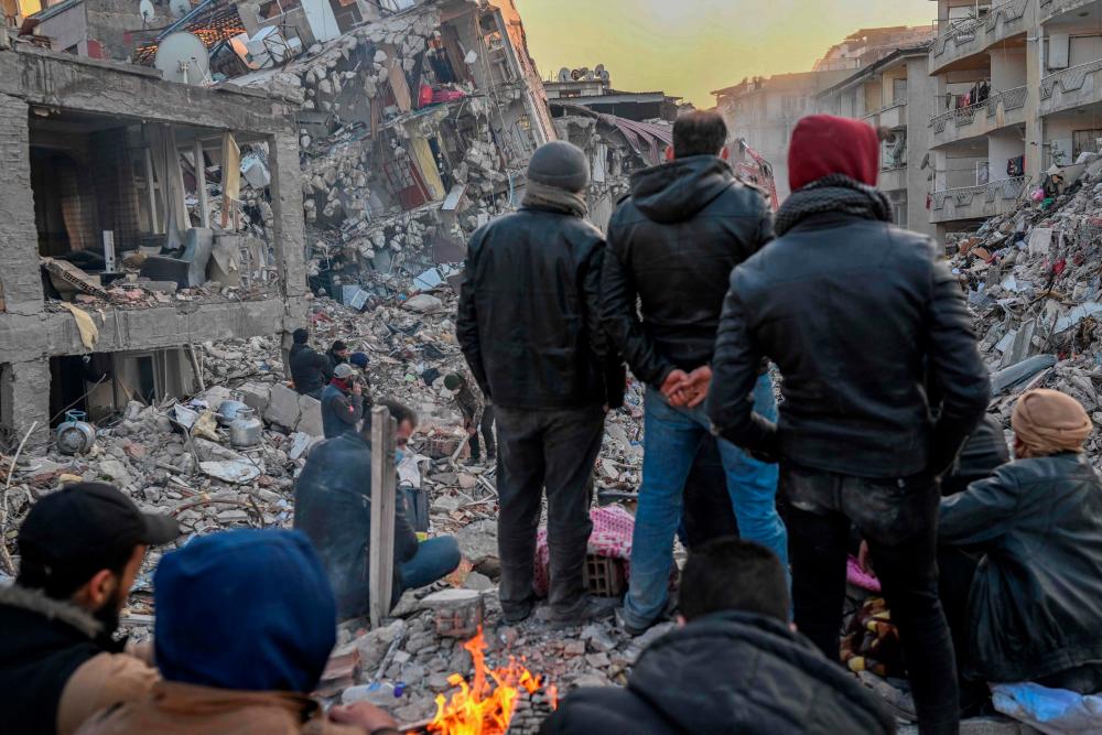 Local residents, whose loved ones are still under the rubble, look at the collapsed buildings in Hatay on February 14, 2023, a week after a 7,8-magnitude earthquake struck parts of Turkey and Syria. AFPPIX