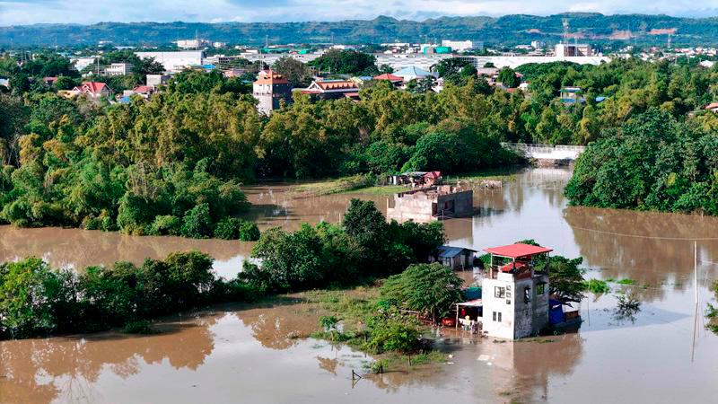 This aerial photo shows a flooded area due to the heavy rains brought about by Tropical Storm Trami in Tuguegarao City, province of Cagayan on October 25, 2024. Philippine rescue workers battled floodwaters on October 25 to reach residents still trapped on the roofs of their homes as Tropical Storm Trami moved out to sea after killing at least 40 people. - John Dimain / AFP