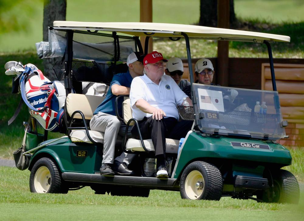 US President Donald Trump sits next to Japanese Prime Minister Shinzo Abe in a golf cart as Abe drives while they play golf at Mobara Country Club in Mobara, Chiba prefecture, Japan May 26, 2019, in this photo taken by Kyodo. - Reuters