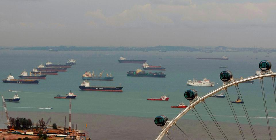 Container ships and bulk freighters are pictured in the shipping lanes off the coast of Singapore, as the Singapore Flyer observation wheel is seen in the foreground, March 13, 2009. REUTERSPIX
