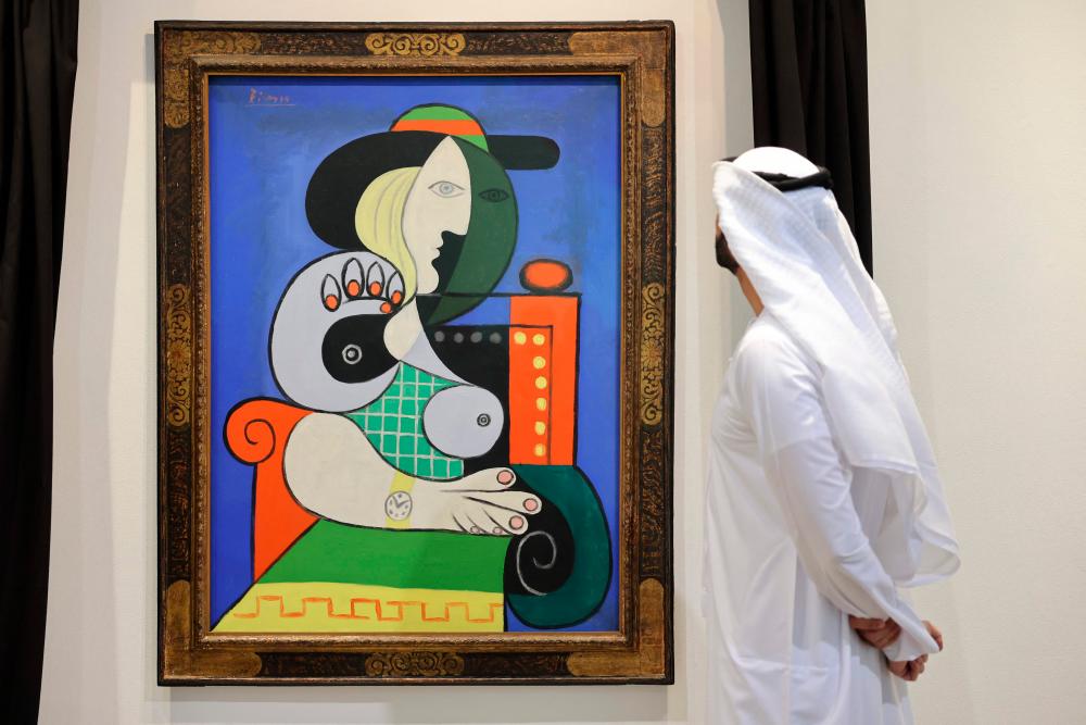 A visitor looks at Pablo Picasso’s painting ‘Femme à la montre’ displayed for viewing at Sotheby’s Dubai on September 25, 2023/AFPPix