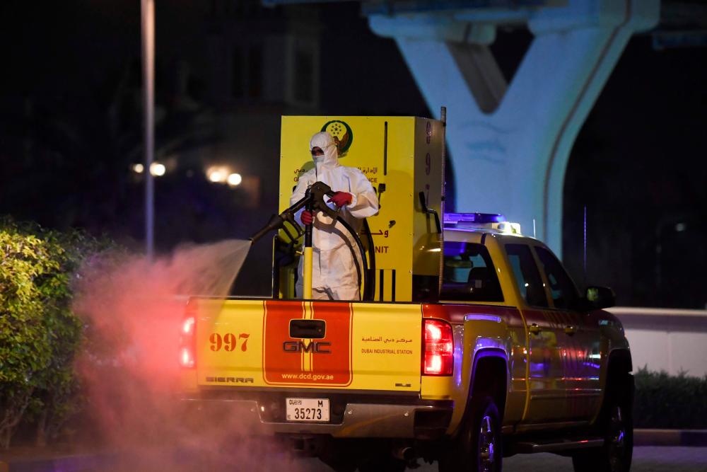 A municipal workerr disinfects the streets of the Palm Island in Dubai as a preventive measure against the spread of the novel coronavirus in the Emirate city on March 28, 2020. - AFP