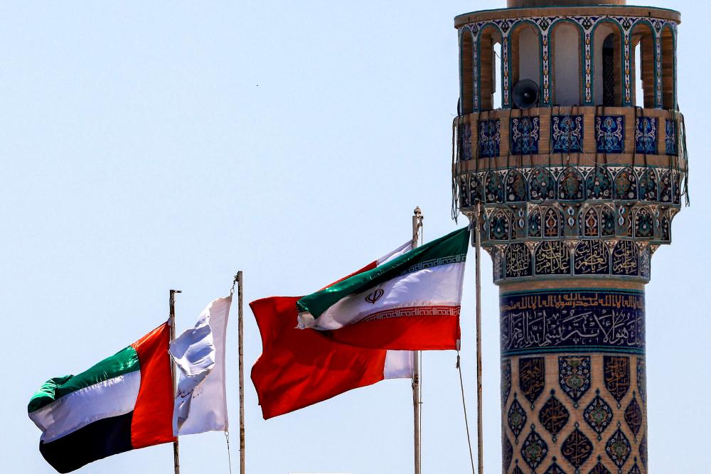 The flags of Iran (R) and of the UAE (L) fly above a building at the complex housing Iran’s consulate headquarters in Dubai on April 5, 2023. AFPPIX