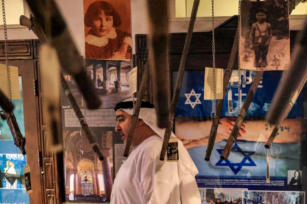 Ahmed al-Mansoori, director of the “Crossroads of Civilizations Museum”, shows visitors around the Holocaust Gallery at the facility in Dubai on January 11, 2023. AFPPIX